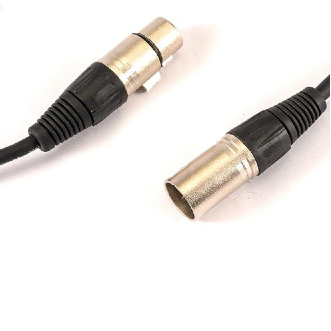 Les câbles XLR noirs du microphone, de l'homme à la femme, conduisent le câble du microphone au mixeur.